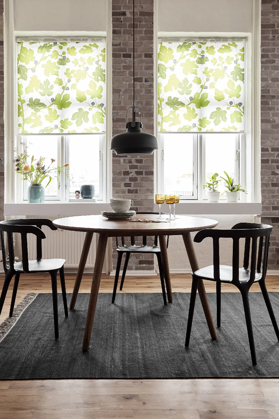 Matplats vid tegelvägg med rullgardiner i två fönster