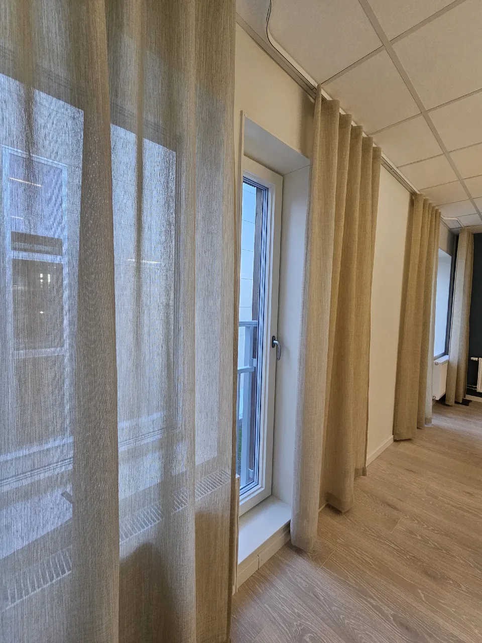 Korridor med gardiner längs fönsterväggen