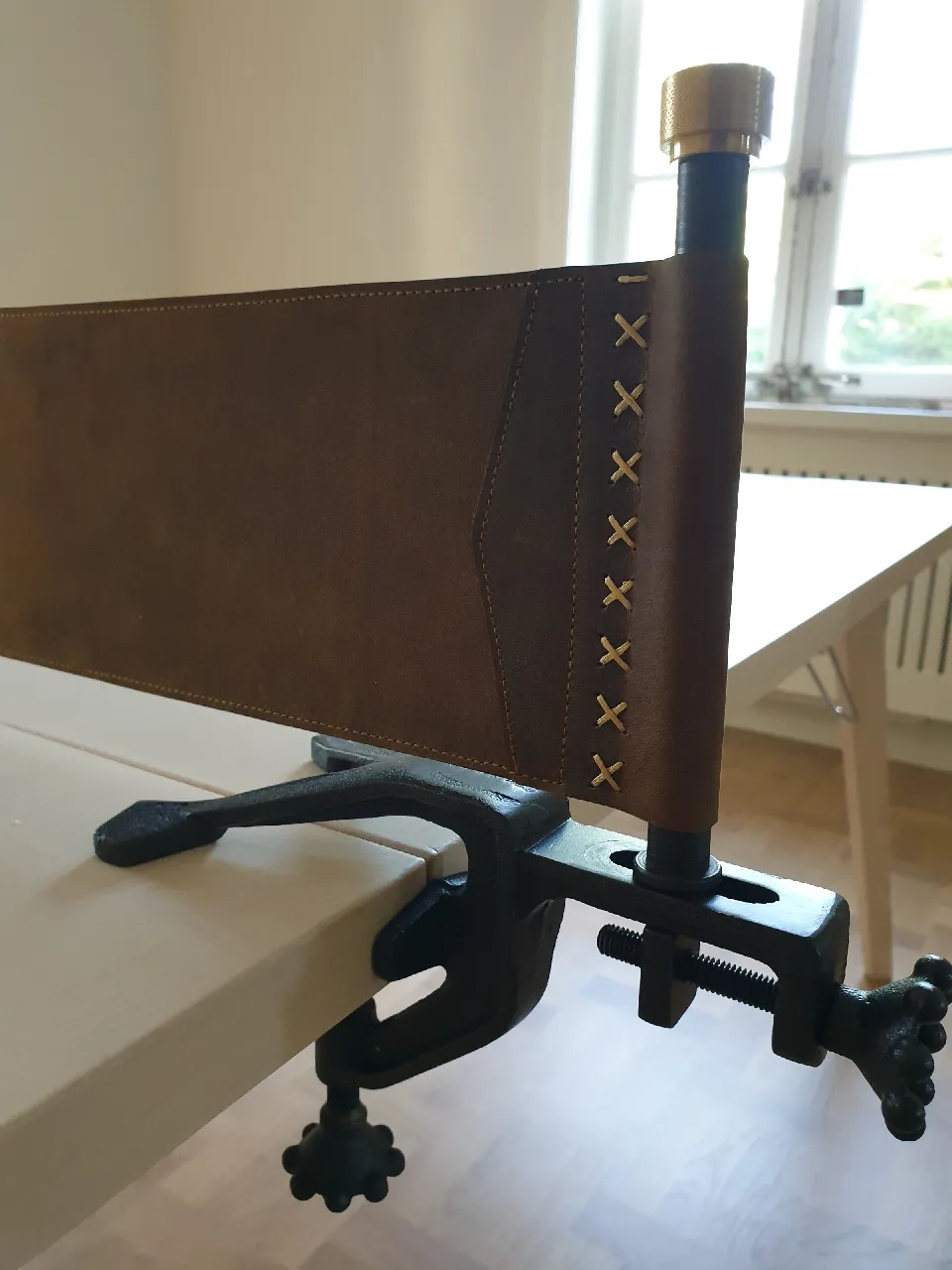 Närbild på ryggen av en läderstol vid ett bord
