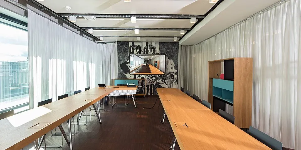 Möteslokal med långbord och akustikgardiner