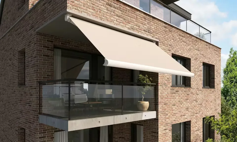 Balkong på ett tegelhus med utfälld terrassmarkis