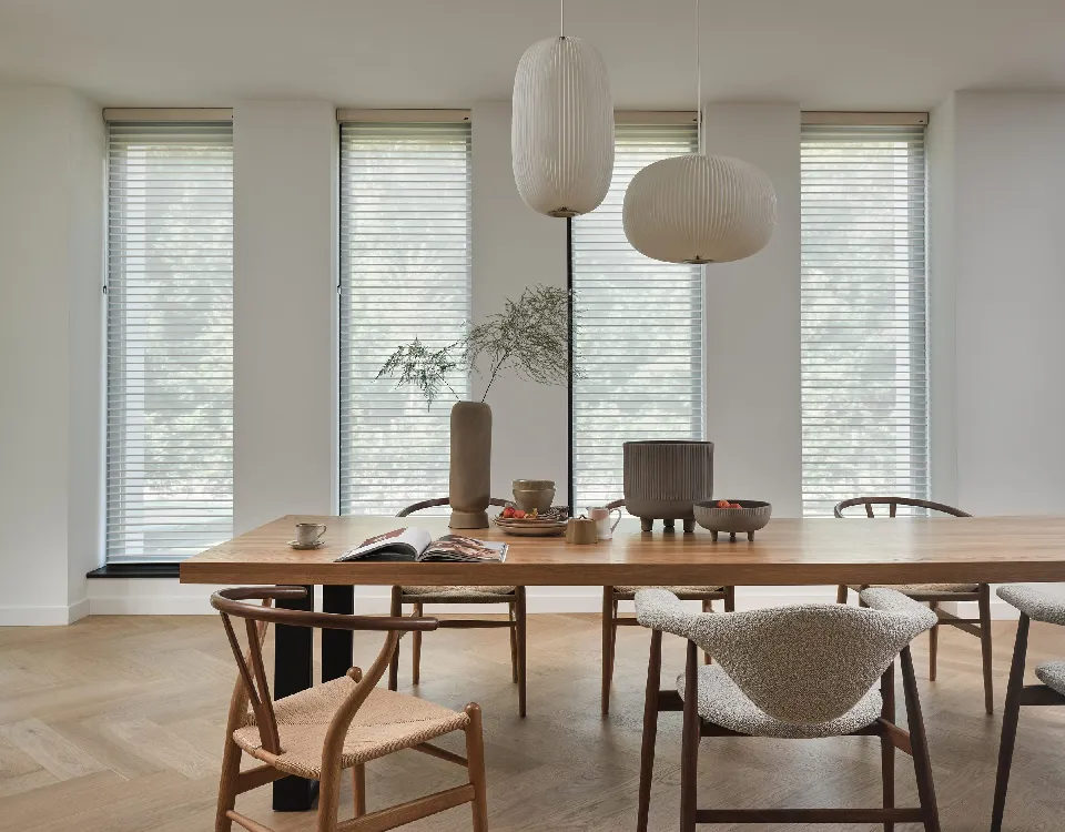 Matplats med runda taklampor och Silhouette-gardiner i tre fönster