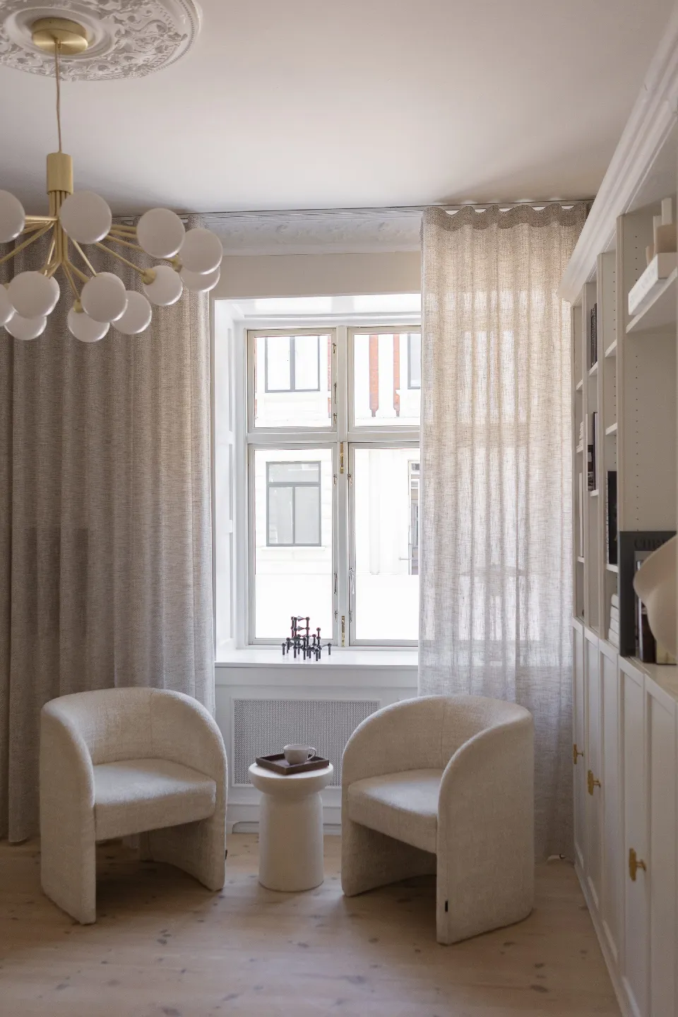 Transparenta linnegardiner i ett fönster med matplats