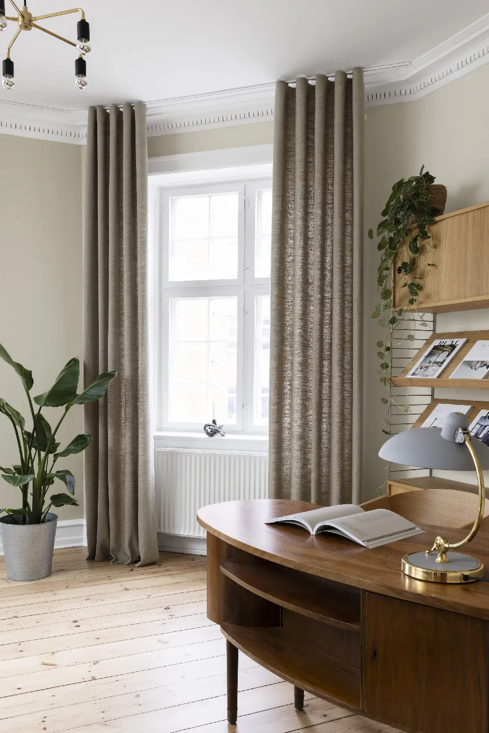 Arbetsrum med skrivbord och gråbruna gardiner