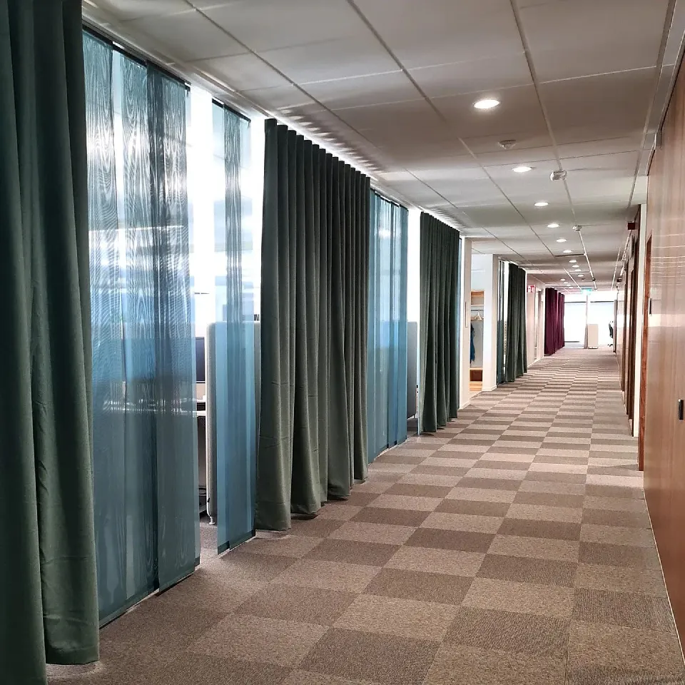 Korridor med gardiner i flera färger längs glaspartierna
