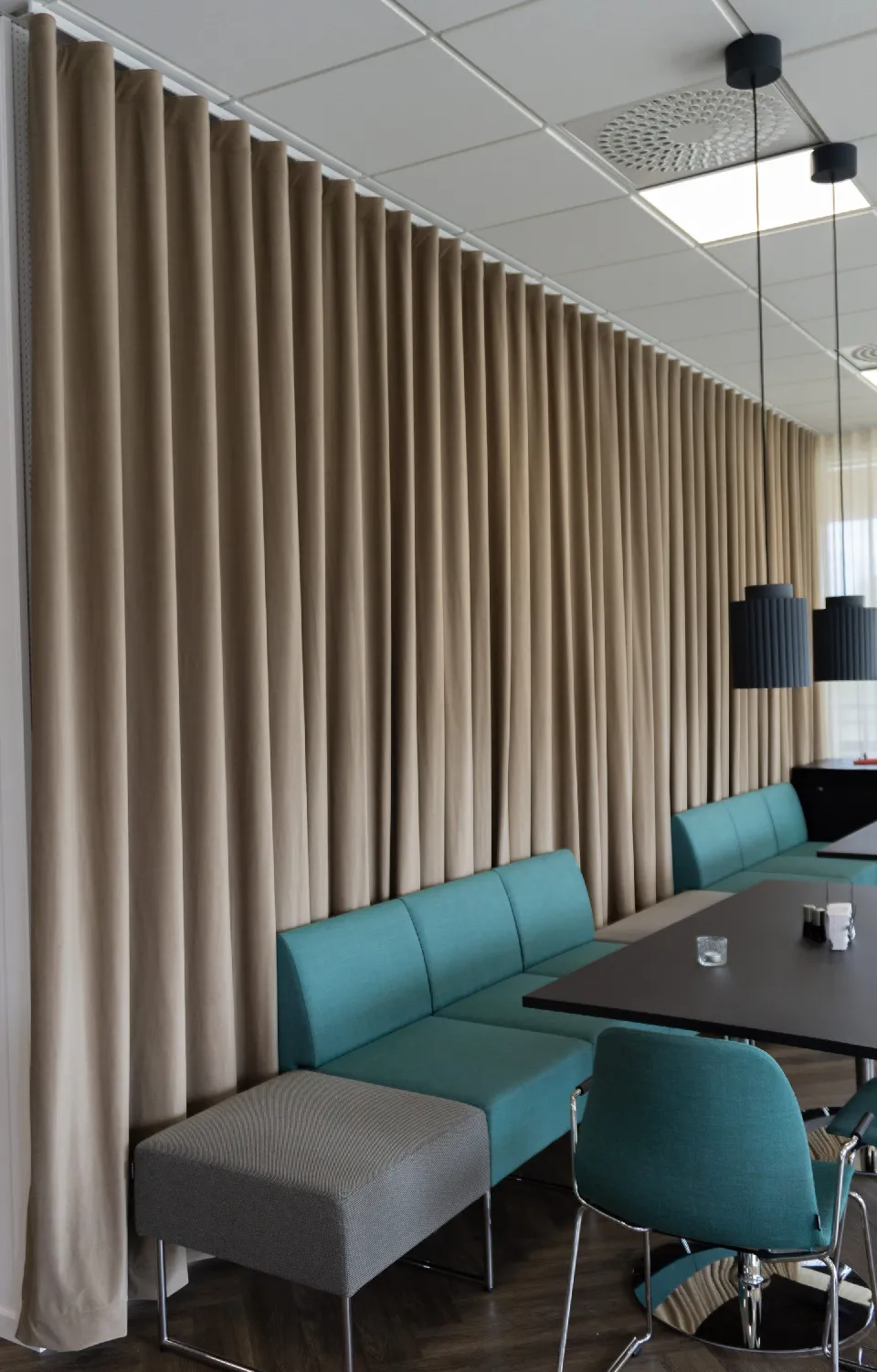 Kontorslokal med bänkbord och beiga gardiner längs väggen