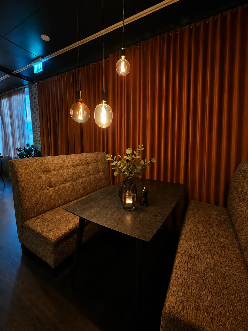 Sittbås med soffa framför gardiner i flera färger
