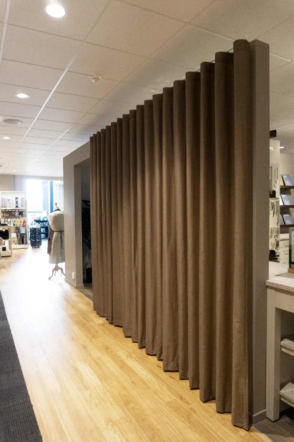 Butiksavdelning avskärmad med en gardin i naturton