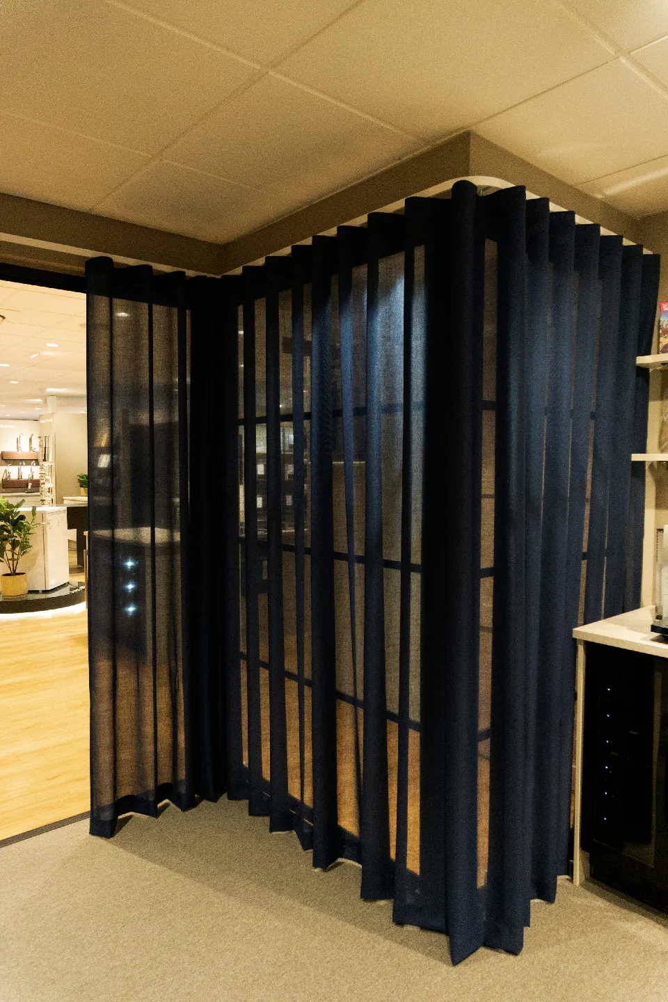 Mörkblå gardiner vid ett glasparti i en butik