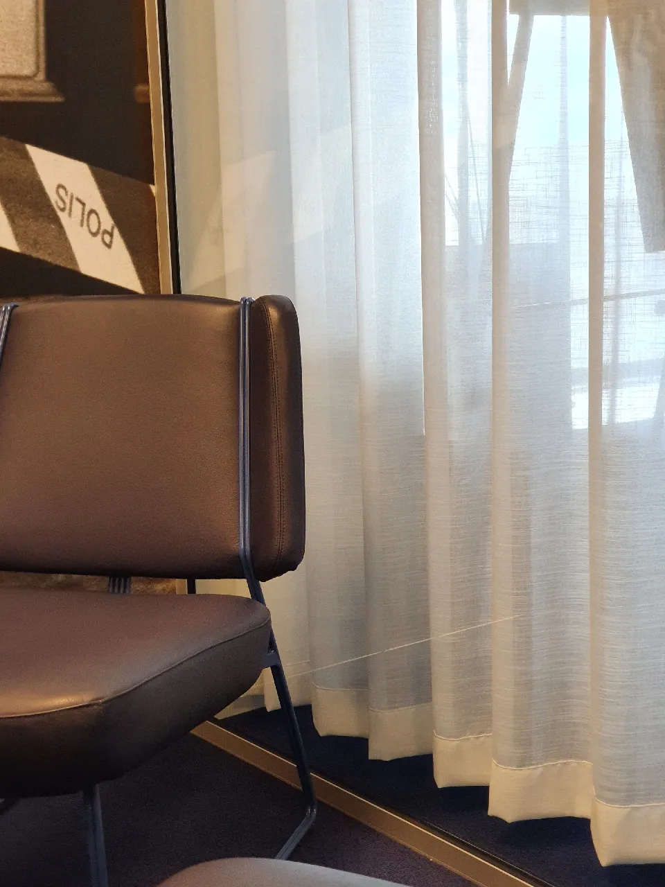 Läderfåtöljer framför ljusa gardiner
