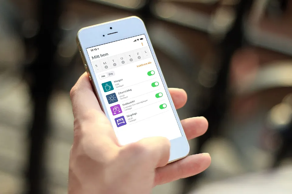 Hand som styr gardinerna i en app på en mobiltelefon